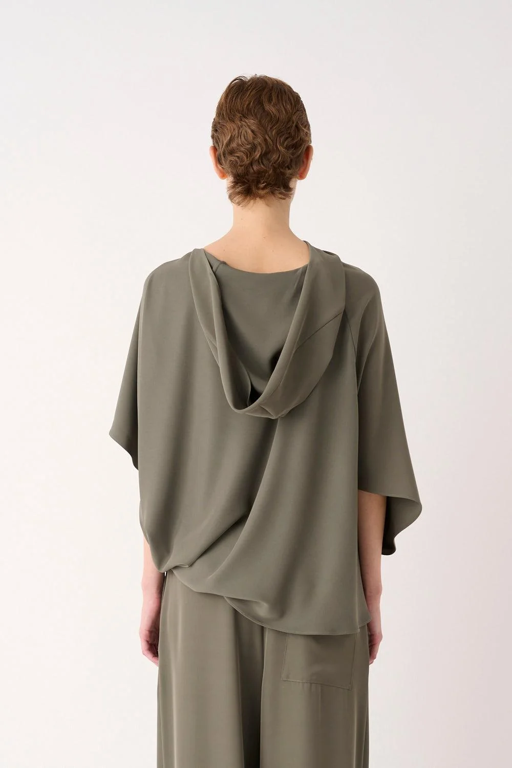 Blusa Asimmetrica con Cappuccio Mei Mei J | FYSIS STORE Dettaglio posteriore della blusa asimmetrica Mei Mei J con cappuccio drappeggiato